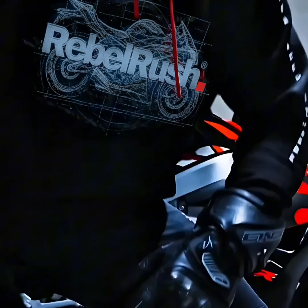 Motocyklista w bluzie RebelRush Blueprint 2.0 kucający przy sportowym motocyklu